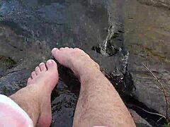 Mikas store og behårede fødder nyder barfodet leg i vandet
