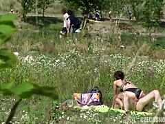 Una adolescente en bikini con tetas pequeñas es follada en público ante la cámara