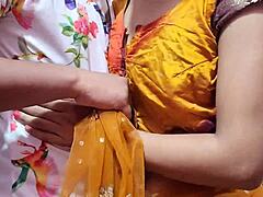 Chlupatá indická tínedžerka v žltom sári dostáva krém od svojho šéfa