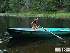Η χαριτωμένη κοπέλα απολαμβάνει την ευχαρίστηση του εαυτού της σε μια βάρκα με ένα dildo